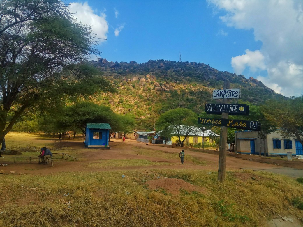 Sign for Tembea Mara campsite with a hill in the background