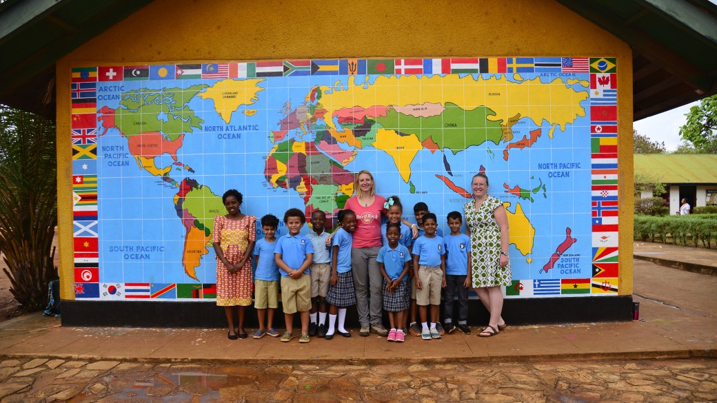 Me with a Year 3 class and teachers in front of a mural with a world map